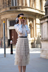 a lady in a printed top and a tiered skirt